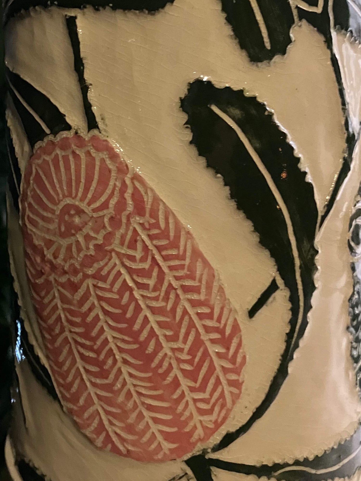 Flower detail of a tall ceramic sculpture with pink banksia flowers and mosaic inlay