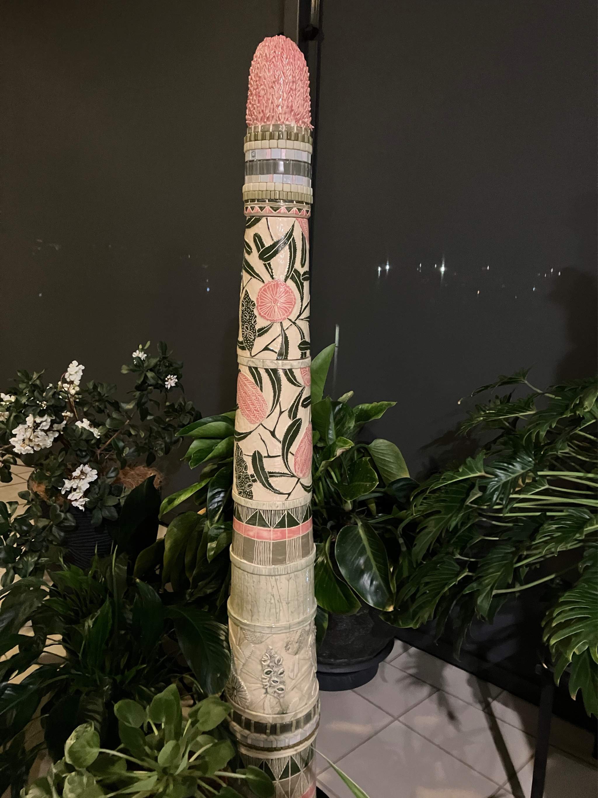 Tall ceramic sculpture with pink banksia flowers and mosaic inlay